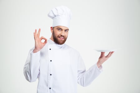 Portrait of a man chef showing ok sign and empty plate isolated on a white background-1