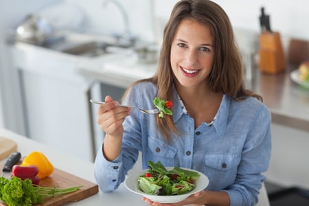 Pretty woman eating a salad in the kitchen-1