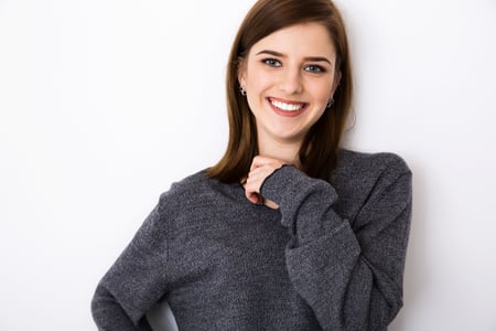 Portrait of a cheerful young woman over gray background