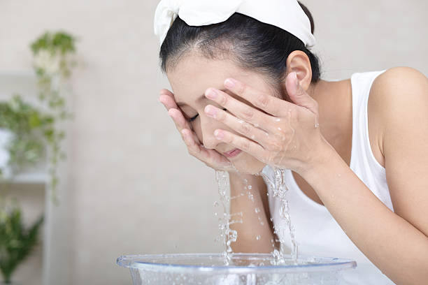 女性の顔を洗う - 洗顔 ストックフォトと画像